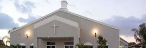 A white church with a cross on the front built with the help of Walker Design and Construction
