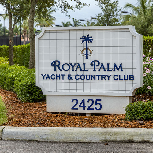 Royal Palm Yacht & Country Club white sign with blue lettering.