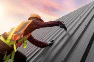 A worker installs a metal commercial roof