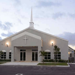 A white church with a cross on the front built with the help of Walker Design and Construction