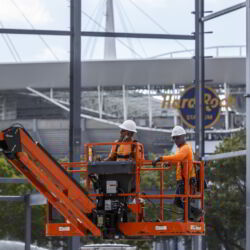 Two construction workers on a lift.
